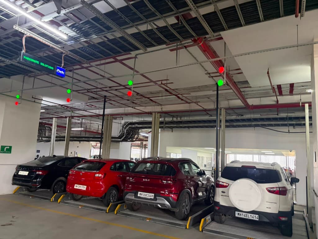 Multi-level parking bays with red/green LED occupancy indicators and Parkonate display board overhead